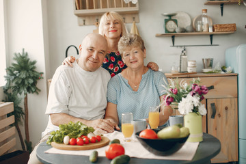 Family in a kitchen. Grandparents with grandchildren. People with vegetables