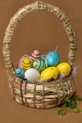 Fototapeta na wymiar Wicker basket with red Easter eggs on a brown background