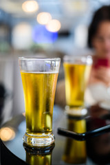 Glass of beer in bar and mobile phone on a table