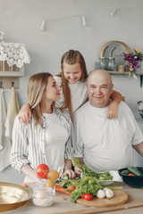 Family in a kitchen. Grandparents with grandchildren. People with vegetables