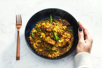 plant-based food, spicy apricot curry with mixed vegetables and vegan sausages