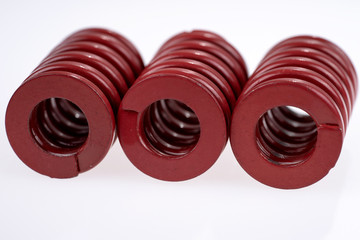 Three red strong metal springs isolated on a white background