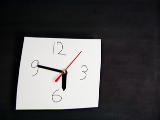 Clock made out of paper isolated against a black background