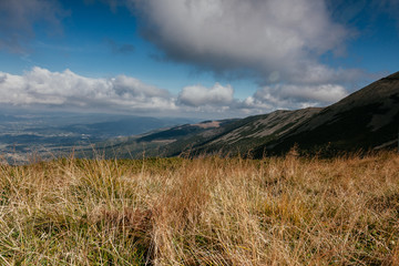 Autumn mountain landscape with blue sky and clouds 