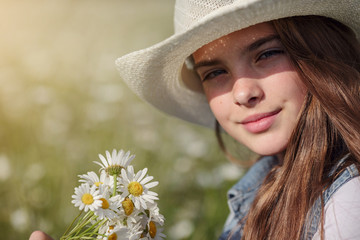beautiful girl in denim in a camomile field