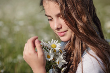 beautiful girl in denim in a camomile field