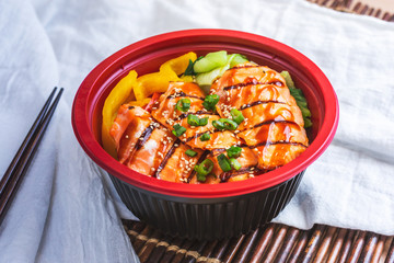 A view of a salmon rice bowl, in a restaurant or kitchen setting.
