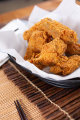 A view of a basket of Korean fried chicken, in a restaurant or kitchen setting.