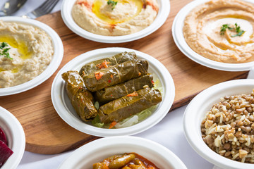 A view of several Mediterranean appetizer dishes, in a restaurant or kitchen setting, featuring...