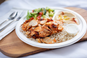 A view of a plate of chicken shawarma, in a restaurant or kitchen setting.