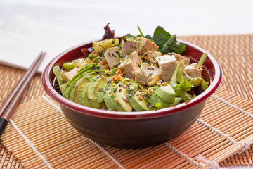 A view of a vegetarian poke bowl, in a restaurant or kitchen setting.