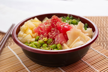 A view of an ahi tuna poke bowl, in a restaurant or kitchen setting.