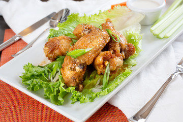 A view of Korean spicy chicken wings, in a restaurant or kitchen setting.