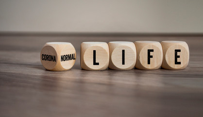 Cubes and dice with normal life and corona life on wooden background