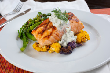 A view of a salmon dinner plate, in a restaurant or kitchen setting.