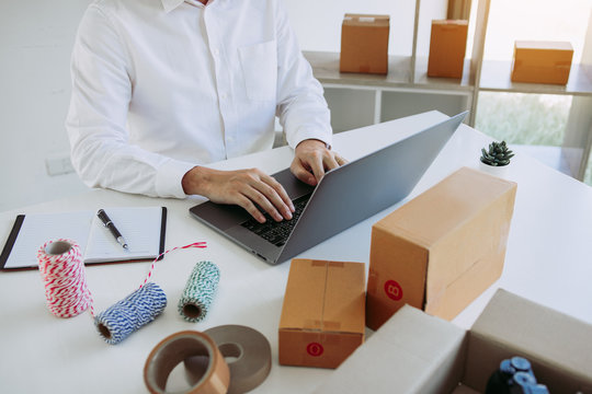 Entrepreneurs are working on taking orders of customers products by typing information tpying keyboard laptop computer in office room.