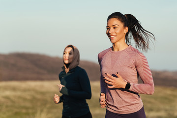 Dedicated athletic women jogging together in nature.