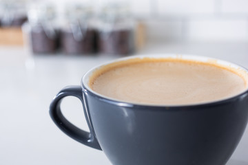 A closeup view of a mocha latte coffee mug in a cafe setting.