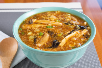 A view of a big bowl of Chinese hot and sour soup in a restaurant or kitchen setting.