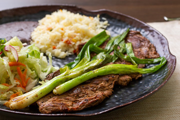 A view of a carne asada plate in a restaurant or kitchen setting.
