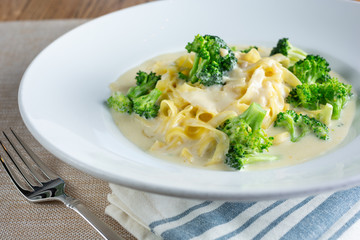 A view of a plate of Fettuccini Alfredo in a restaurant or kitchen setting.