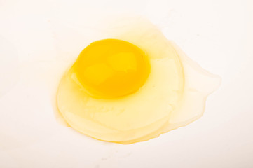 A broken chicken egg without a shell on a white background. Close up.