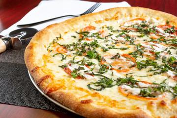 A view of a margherita pizza pie, in a restaurant or kitchen setting.