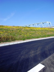 新しい道路と菜の花咲く江戸川土手と鉄橋風景