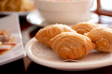 A view of a plate of Thai baked curry puff in a restaurant setting, part of several dishes on a dinner table.