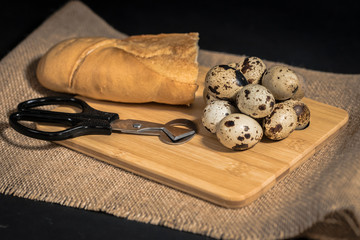 Composición con huevos de codorniz, tijeras y pan