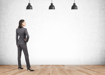 Confident businesswoman looking at blank wall