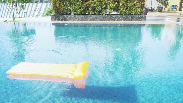 Yellow inflatable mattress float on swimming pool