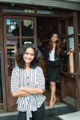 beautiful young asian fashion shop owner at her boutique standing proudly welcoming customer at the store front