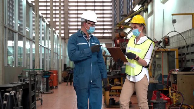 Professional engineering workers walk and check in warehouse factory. Manager discuss inspection report paper for internal audit. Quality assurance for manufacturing. Concept Engineer Operating.