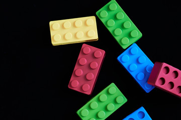 Colorful construction bricks on a black background