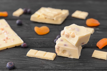 Sweet white chocolate with blueberry and dried apricots on table