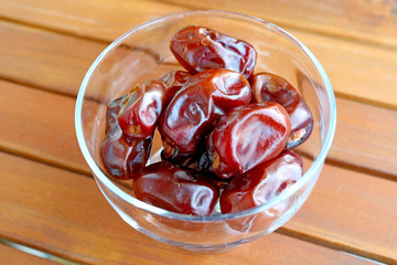 Dried Dates in a Glass Compote on Wooden Table