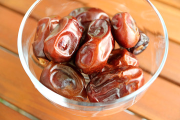 Closeup Dried Dates in a Glass Compote on Wooden Table