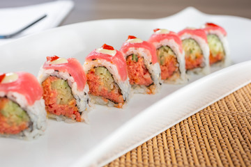 A view of a sushi tuna roll plate, in a restaurant or kitchen setting.