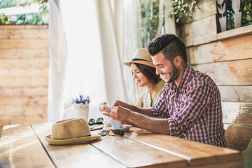 Young couple drinking coffee in vintage cafe bar - Happy tourists having breakfast in travel vacation - Holiday, love, food, stylish, lifestyle and relationship concept - Focus on man face