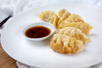 A view of a plate of Japanese gyoza, in a restaurant or kitchen setting.