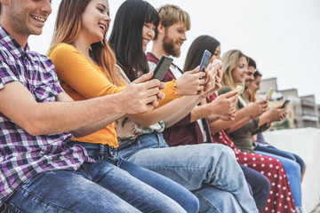 Young friends using smart mobile phones app - Teenagers people addiction to new technology trends - Concept of youth, tech, social and friendship - Focus on hands