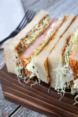 A closeup view of a Japanese Katsu Ham Sando in a restaurant or kitchen setting.