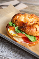A view of a tray of a breakfast croissant sandwich in a restaurant or  kitchen.