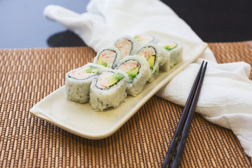 A view of a California Roll plate, in a restaurant or kitchen setting.