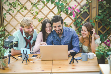 Young people streaming online using laptop, smartphone camera and softbox light - Millennial friends having fun with new technology trend - Social media concept - Soft focus on right man face