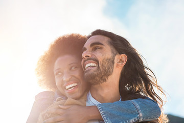Multiracial couple having tender moments outdoor - Caucasian man and african woman having fun together during vacation - Travel, love and multi ethnic relationship concept - Focun on faces
