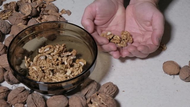 Cracking a walnuts at home.
Hammer to break nuts. Collects a nuts in glass bowl