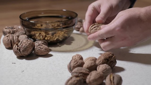 Cracking a walnuts at home.
Hammer to break nuts. Collects a nuts in glass bowl