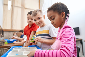 Kids using building kit to create toys.